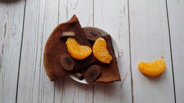 Crêpes au chocolat avec bonbons au chocolat et tranches de mandarine comme petit déjeuner — Video