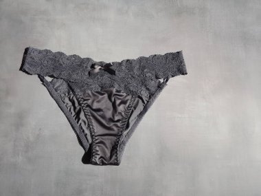 Gri arka planda ipekten yapılmış koyu mavi seksi iç çamaşırı.