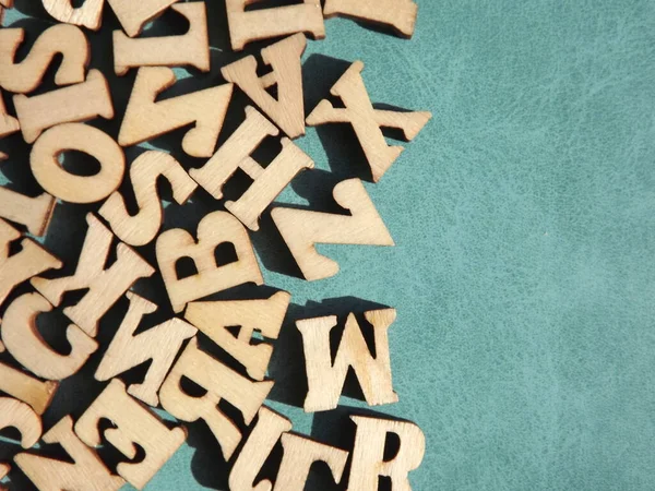 Alfabenin ahşap harfleri mavi bir arkaplanda ve metin için boşluk var