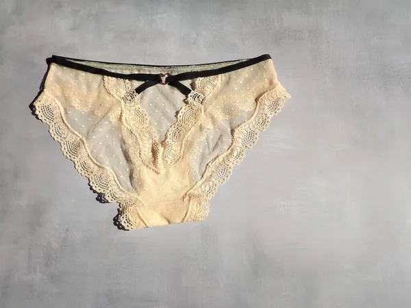Dámské sexy krajky kalhotky v broskvové barvě na šedém pozadí v podobě rozložení — Stock fotografie