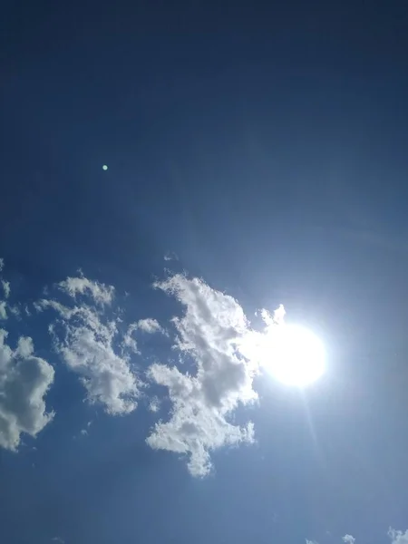 De zon staat achter een puntje aan de blauwe hemel — Stockfoto