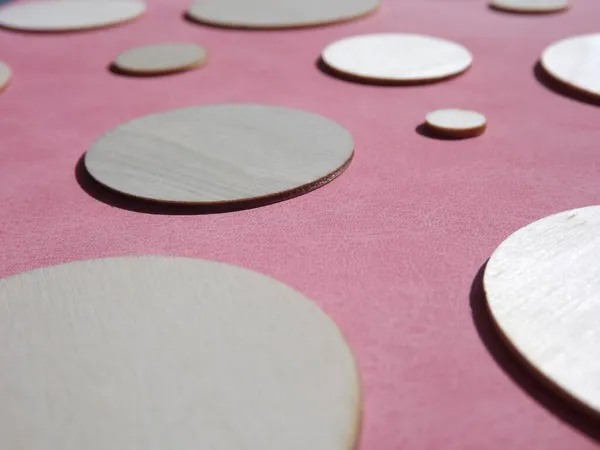 Holzkreise mit unterschiedlichen Durchmessern auf rosa Wildleder — Stockfoto