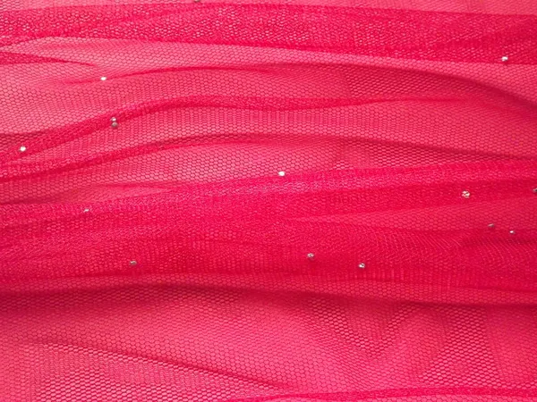 Tulle pink dalam lipatan pada latar belakang merah sebagai latar belakang — Stok Foto
