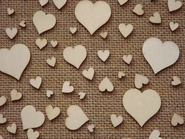 Coeurs en bois de différentes tailles sur tissu de jute comme une carte de voeux Saint-Valentin — Photo