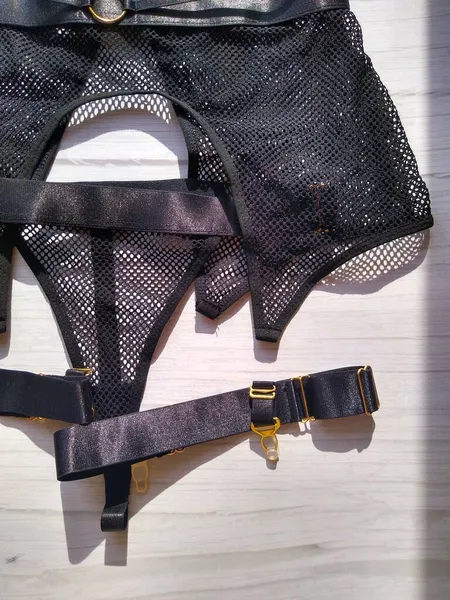 Un conjunto de ropa interior en una malla negra en el estilo BDSM sobre un fondo claro —  Fotos de Stock