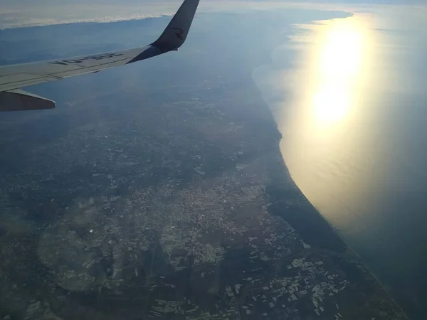 Vista da janela da aeronave no litoral e nuvens — Fotografia de Stock