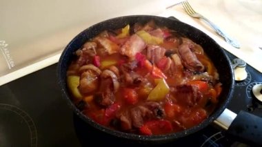 Etleri sebzelerle pişirme işlemi sobanın tavasında yakın planda.