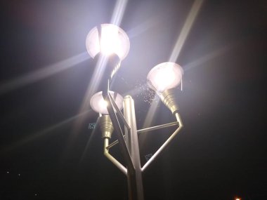 Gece üç fener arasındaki direğin tepesindeki örümcek ağı.