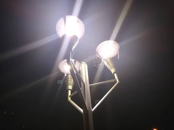 Cobweb on top of a lamppost between three lanterns at night — Stock Photo, Image