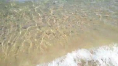 Kıyı şeridinde temiz kum ve su ile yakın plan dalga.