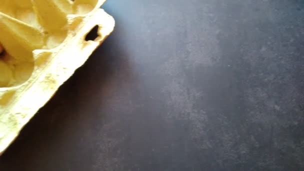 Una mano de mujer toma un huevo beige de una caja de huevos — Vídeos de Stock