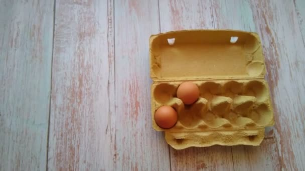 Uma mão de mulher toma um ovo bege de uma caixa de ovo — Vídeo de Stock