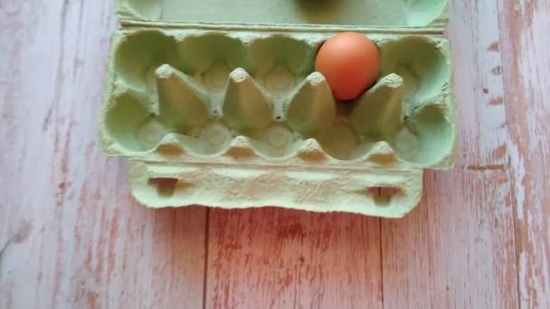 Ženská ruka vytáhne béžové vejce z krabice od vajíček — Stock video