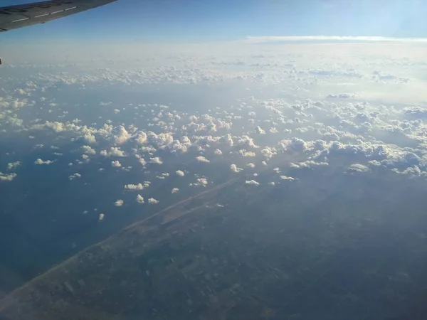 Vista dalla finestra del velivolo sulla costa e nuvole — Foto Stock