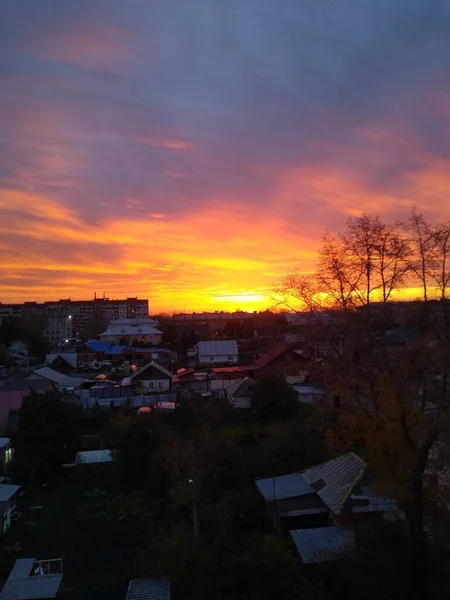 Красивый закат в городе с тяжелыми оранжевыми облаками — стоковое фото