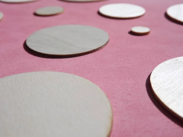 Holzkreise mit unterschiedlichen Durchmessern auf rosa Wildleder — Stockfoto