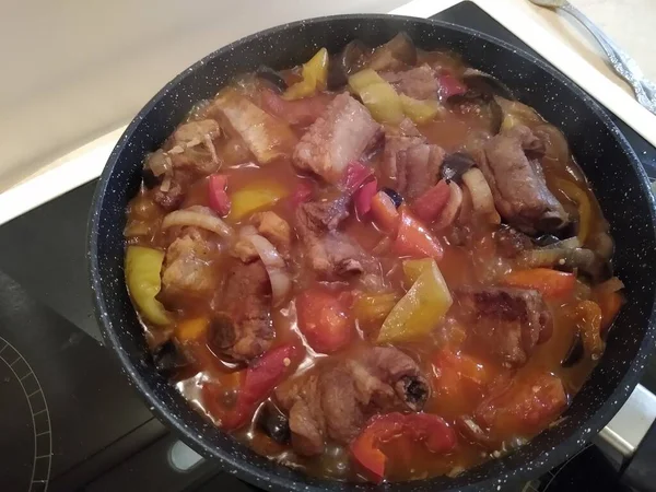 Kokning av kött på ben med grönsaker: lök, morötter, paprika, äggplantor. — Stockfoto