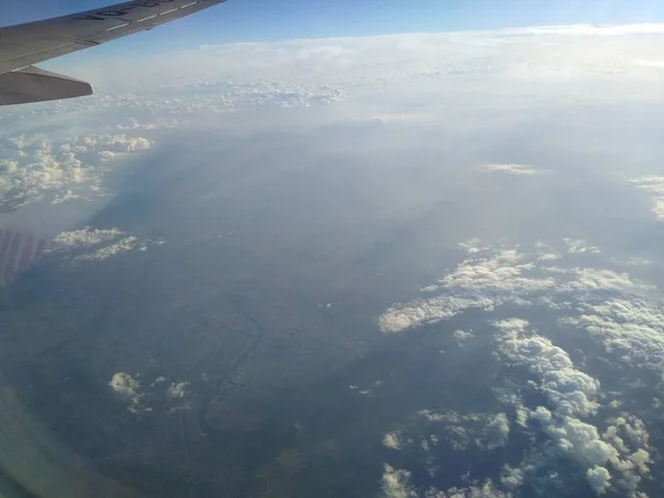 Vista desde la ventana del avión en la costa y las nubes —  Fotos de Stock