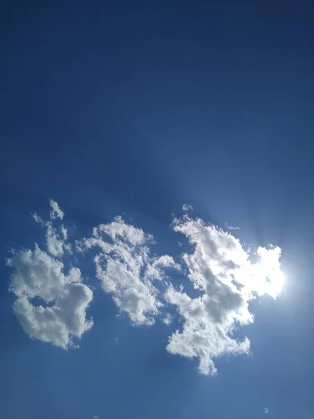 O sol está atrás de um pequeno ponto no céu azul — Fotografia de Stock