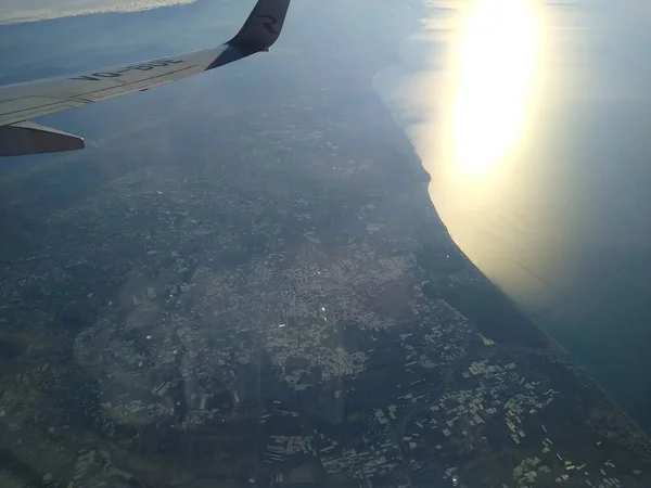 Vista desde la ventana del avión en la costa y las nubes — Foto de Stock