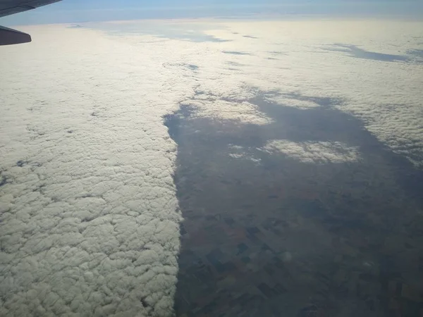 Lihat dari jendela pesawat di garis pantai dan awan — Stok Foto