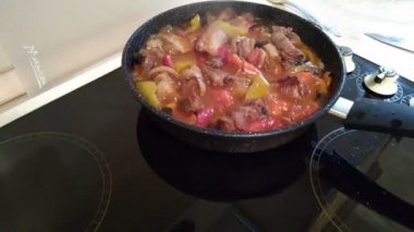 Etleri sebzelerle pişirme işlemi sobanın tavasında yakın planda.