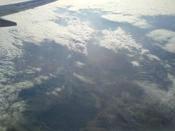 View from the window of the aircraft on the coastline and clouds — Stock Photo, Image