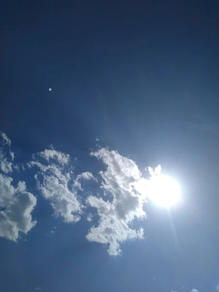 El sol está detrás de un pequeño punto en el cielo azul —  Fotos de Stock