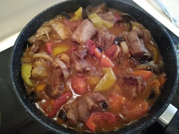 Kokning av kött på ben med grönsaker: lök, morötter, paprika, äggplantor. — Stockfoto