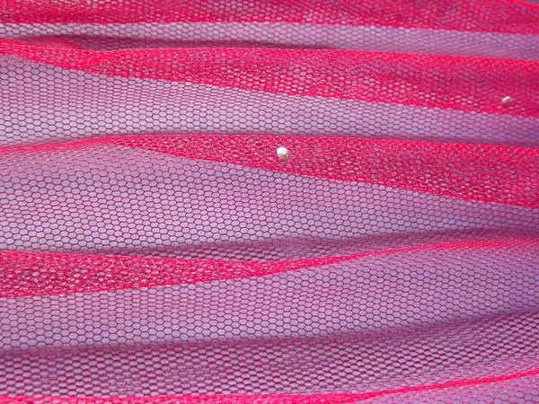 Tulle rosa in una piega su uno sfondo viola come sfondo — Foto Stock