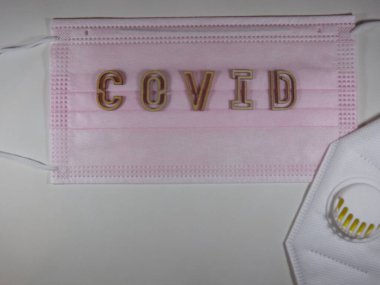 Yüz maskesi üzerinde ahşap harflerle 