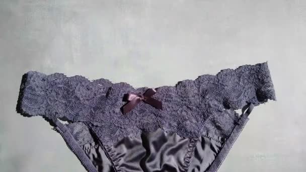 Tmavě modré erotické kalhotky z hedvábí a guipure close-up na šedém pozadí — Stock video