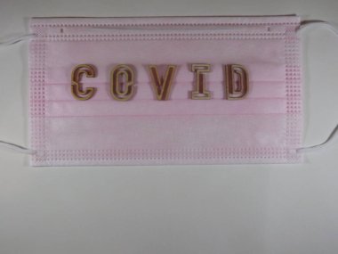 Yüz maskesi üzerinde ahşap harflerle 