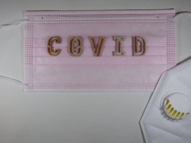 Yüz maskesi üzerinde ahşap harflerle 