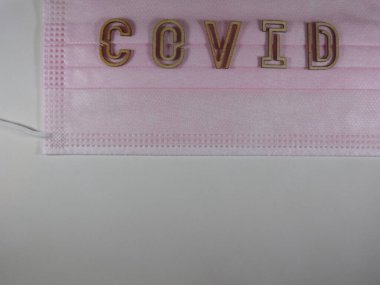 Yüz maskesi üzerinde ahşap harflerle 