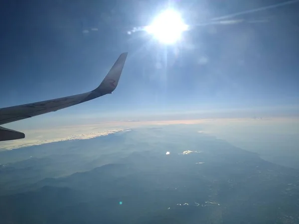 Vue de la fenêtre de l'avion sur le littoral et les nuages — Photo