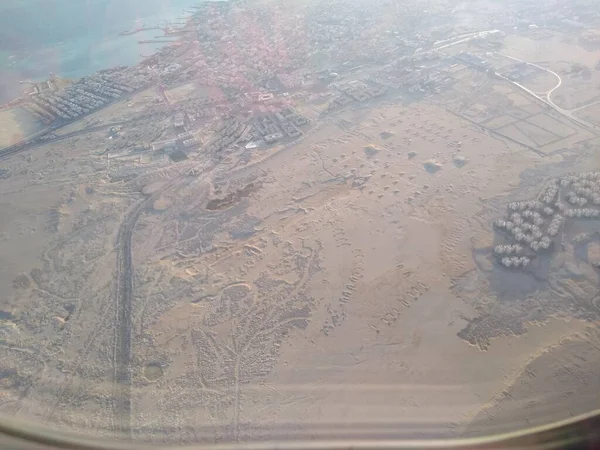 Vue de la fenêtre de l'avion sur le littoral et les nuages — Photo