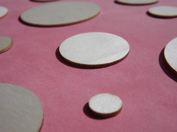 Holzkreise mit unterschiedlichen Durchmessern auf rosa Wildleder — Stockfoto