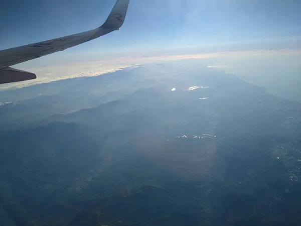 Вид из окна самолета на побережье и облака — стоковое фото