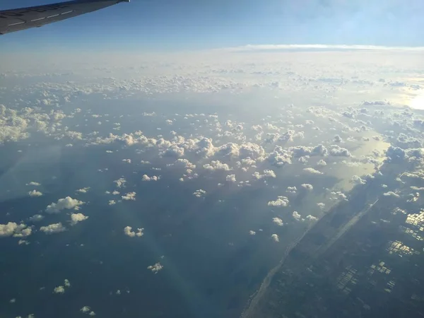 Θέα από το παράθυρο του αεροσκάφους στην ακτογραμμή και τα σύννεφα — Φωτογραφία Αρχείου