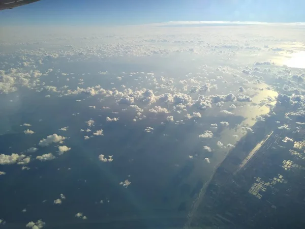 View from the window of the aircraft on the coastline and clouds — Stock Photo, Image