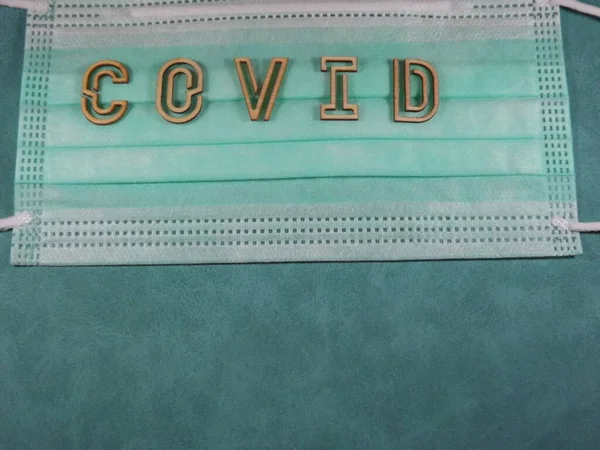Η λέξη covid παραλλαγή omicron με ξύλινα γράμματα στη μάσκα προσώπου — Φωτογραφία Αρχείου