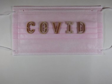 Yüz maskesi üzerinde ahşap harflerle 