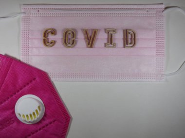 Yüz maskesi üzerinde ahşap harflerle 