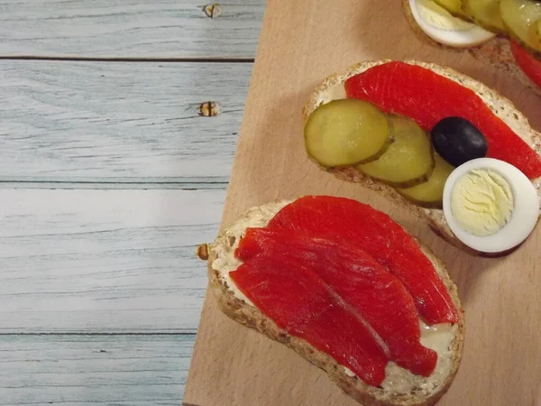 Somon, alabalık, somon balığı, salatalık, yumurta ve zeytinli sandviç.