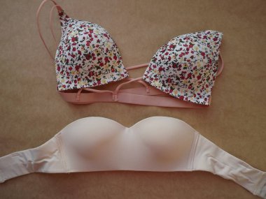 Bej arka planda farklı kadınların bej sutyenleri.