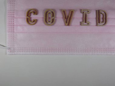 Yüz maskesi üzerinde ahşap harflerle 