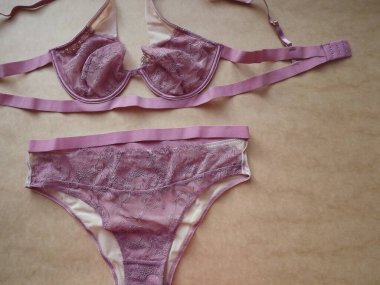 Pembe leylak rengi Guipure. Bej arka planda seksi kadın iç çamaşırları.