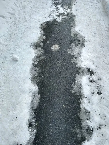 Asphaltpfad mit geschmolzenem Schnee in Nahaufnahme — Stockfoto