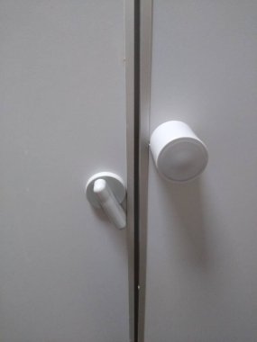 Tuvalet kapısının mandalı beyaz renkte.